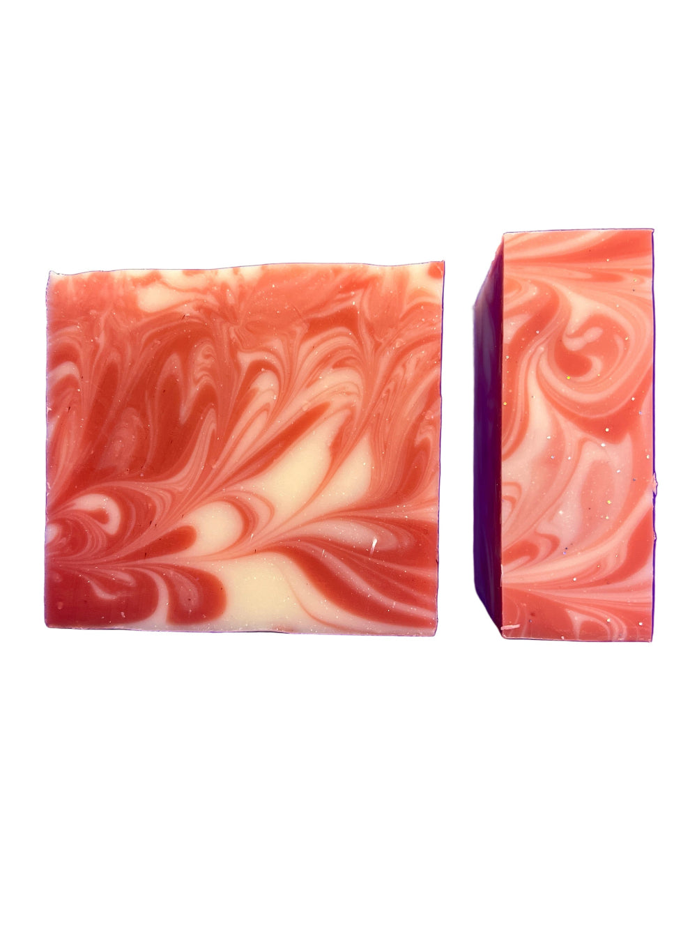 Two swirled peppermint soap bars with red and white patterns on a white background
